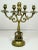 This striking antique brass candelabrum offers both architectural presence and symbolic depth. The central column anchors...