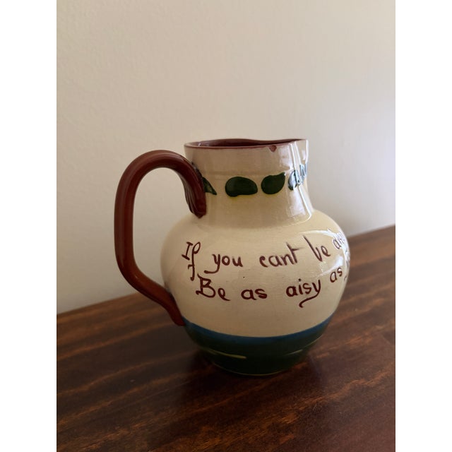 A charming English Torquay pottery pitcher from Devon, England, featuring the whimsical hand-painted phrase: “If you can’t...