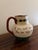 A charming English Torquay pottery pitcher from Devon, England, featuring the whimsical hand-painted phrase: “If you can’t...