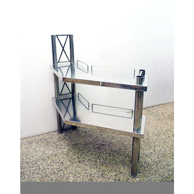Console in polished steel, Italian production from the 70s. Composed of two trellis columns and two corner shelves, ideal...