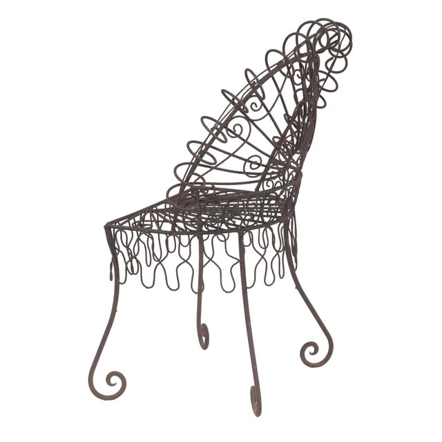 Vintage Salterini style peacock chair featuring a distinctive fan shaped back with intricate wire work.