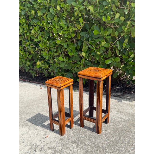 A handsome pair of vintage graduated rattan plant stands featuring geometric stepped tops, tightly wrapped rattan...