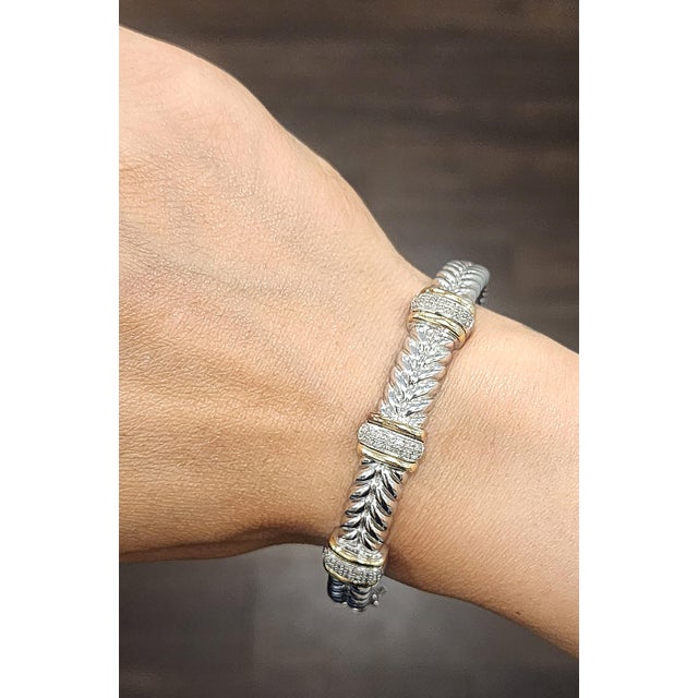 This elegant bangle bracelet exudes a modern charm. Featuring round white diamonds, the piece is crafted with precision...
