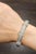 This elegant bangle bracelet exudes a modern charm. Featuring round white diamonds, the piece is crafted with precision...