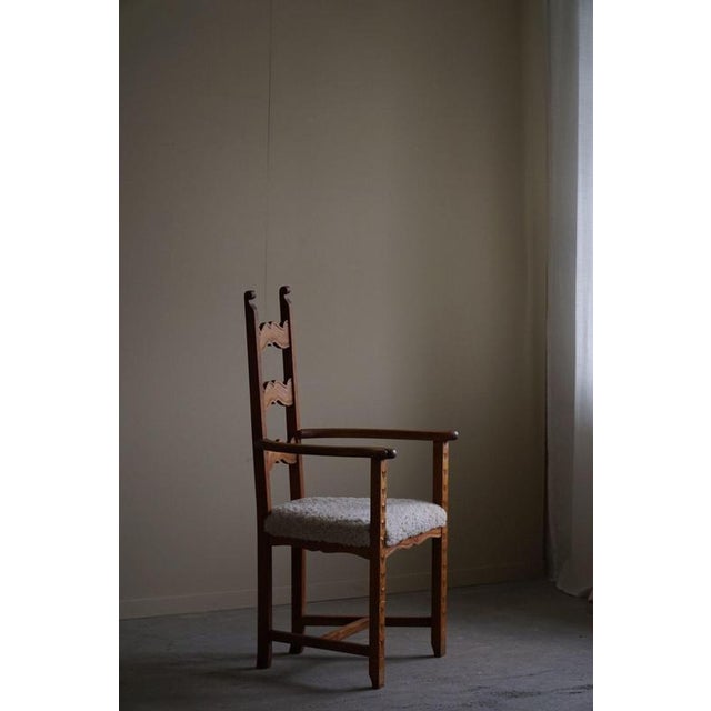 This Danish Mid-Century Modern armchair from the 1950s is crafted from oak with delicate carvings for added detail. The...