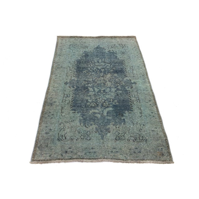 This vintage overdyed Persian wool rug features a captivating blue and gray color field with charming black floral...