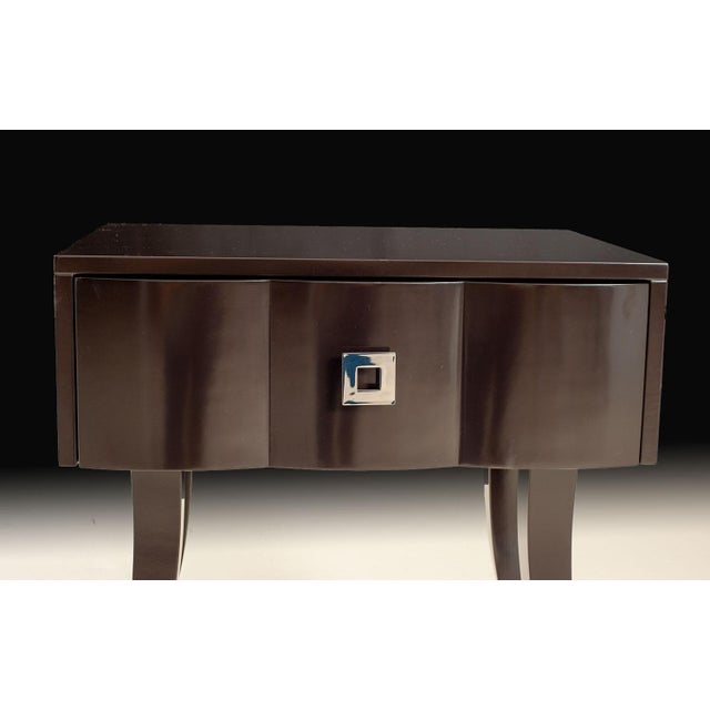 This transitional night stand pairs a sleek black lacquer finish with a gracefully curved drawer front and tapered legs....