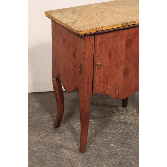 An Italian small sized raised cabinet, with lift top access, from the 19th century. This antique side chest from Italy has...