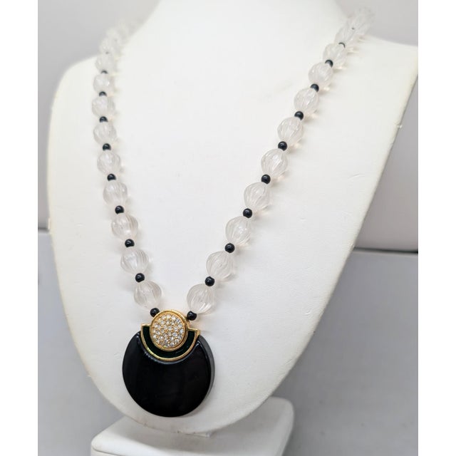 1980s goldtone black Lucite with hunter green enamel and pave clear rhinestones pendant with melon clear Lucite beads and...
