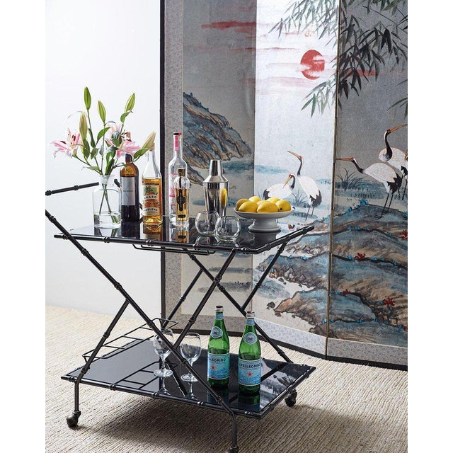 Chic Italian rolling bar cart having a black anodized metal faux bamboo frame. Hollywood Regency design with a modern...