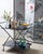 Chic Italian rolling bar cart having a black anodized metal faux bamboo frame. Hollywood Regency design with a modern...