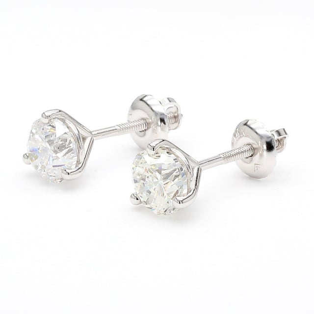 14K white gold diamond stud earrings feature two round brilliant-cut natural diamonds totaling over 2.00 carats, secured...