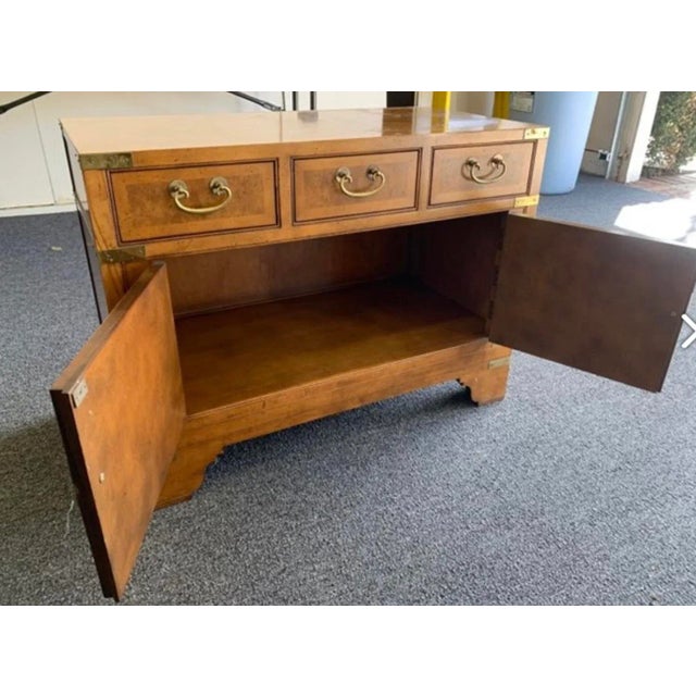 Baker campaign burled walnut nightstand. Mid century nightstand is well made. Burled walnut with 3 drawers. Stand is in...