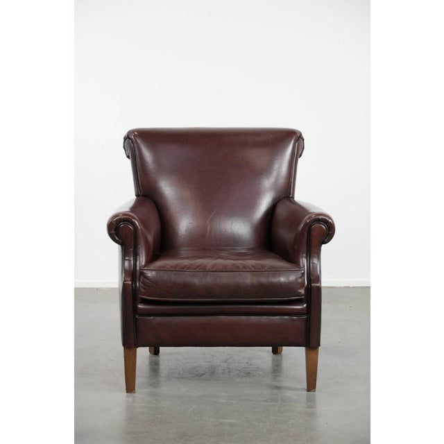 This luxurious armchair is crafted from sheepskin and boasts a beautiful, warm, dark color. It features a loose seat...