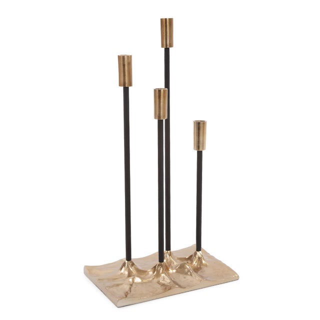 This candle holder is a contemporary take on a classic candelabra. 4 black stems are set into a flat gold aluminum base,...