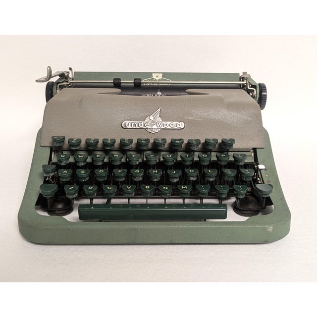 A 1954 Underwood portable typewriter with the original case. The vintage Jewell typewriter is an asparagus green and beige...