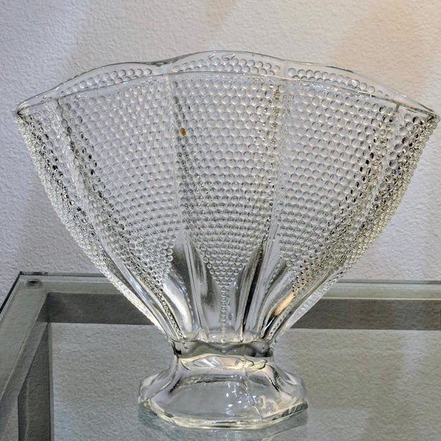 This vintage clear glass fan vase features a dramatic flared silhouette with paneled sides covered in a crisp hobnail...
