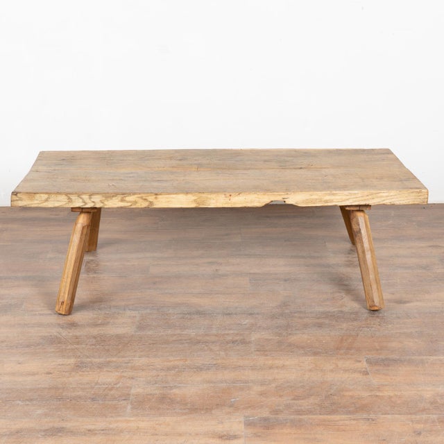 The appeal of this rustic coffee table comes from the wood top that originally served as a worktable, all resting firmly...