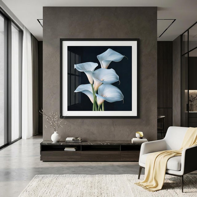 A graceful arrangement of calla lilies unfolds against a deep, shadowy background. Sculptural petals reveal icy blue...