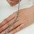 This Art Deco 5.74 Ct Natural Emerald Channel-Set Tennis Bracelet is crafted in 925 sterling silver, featuring a...