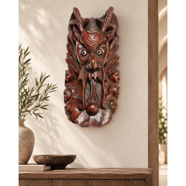 A remarkably expressive vintage Indonesian hand-carved wood wall mask depicting a horned demon or guardian figure, most...