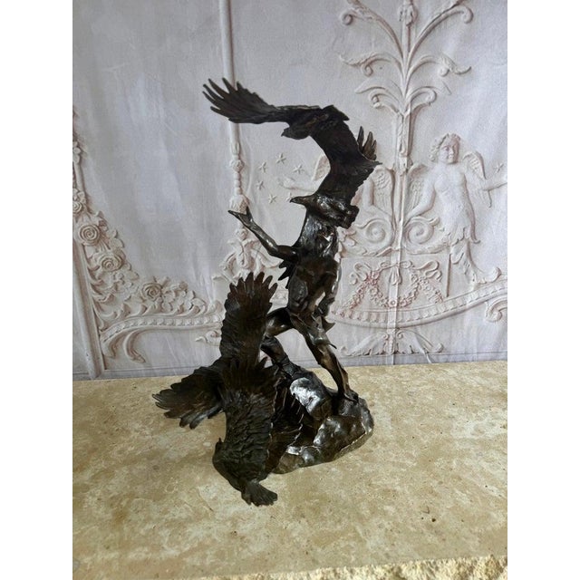 An extraordinary monumental bronze-style sculpture depicting a dramatic interaction between a Native warrior figure and...