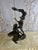 An extraordinary monumental bronze-style sculpture depicting a dramatic interaction between a Native warrior figure and...