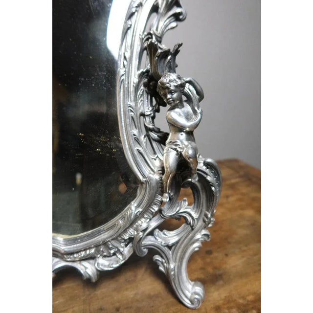 Table mirror in silver bronze style Louis XV. This mirror with candle cherubs is very finely chiseled. We point out a...