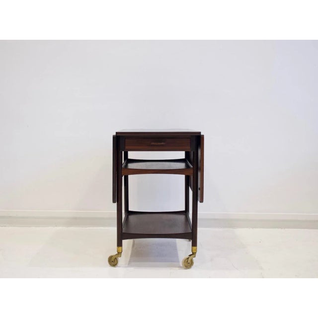 - A serving cart made of wood with two cloves - Top covered with black Formica - Designed by Ludvig Pontoppidan - Two...