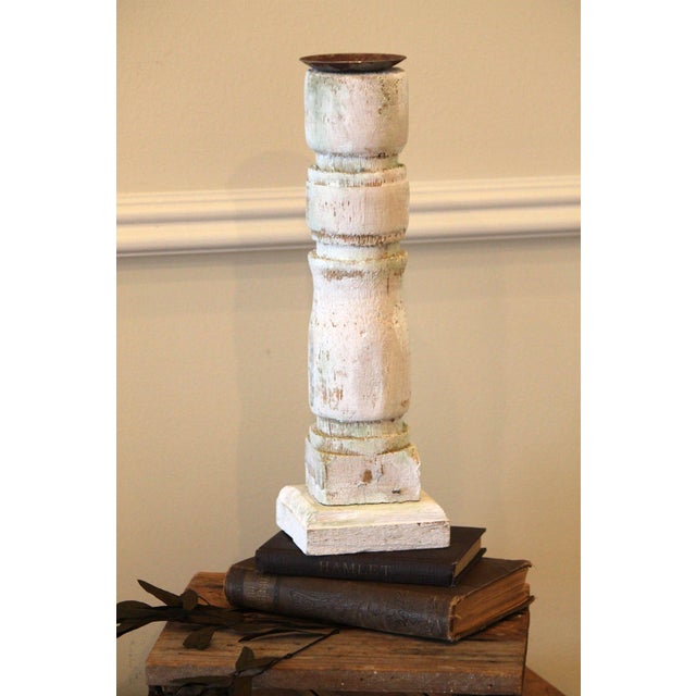 This is a reclaimed, salvaged old baluster that has been converted into a candleholder. Attached to the wood square base...