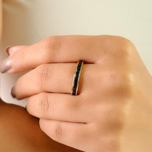 This elegant half eternity band features 13 square-cut natural blue sapphires with a total weight of 1.21 carats. Each...