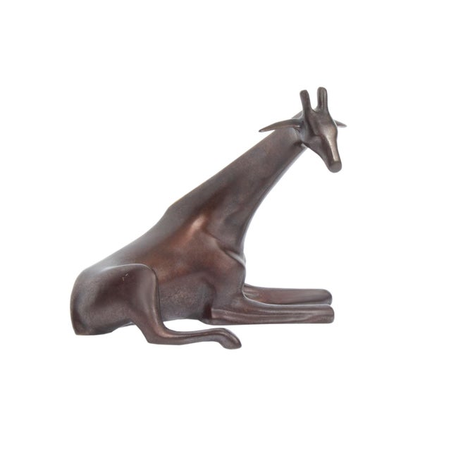 A bronze sculpture by the Dutch sculptor Loet Vanderveen (1921-2015). This sculpture depicts an elegant giraffe, seated...