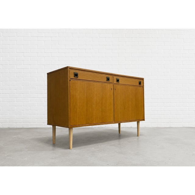 Danish Mid Century Modern oak credenza, c. 1960’s featuring clean architectural lines, tapered solid wood legs, and...