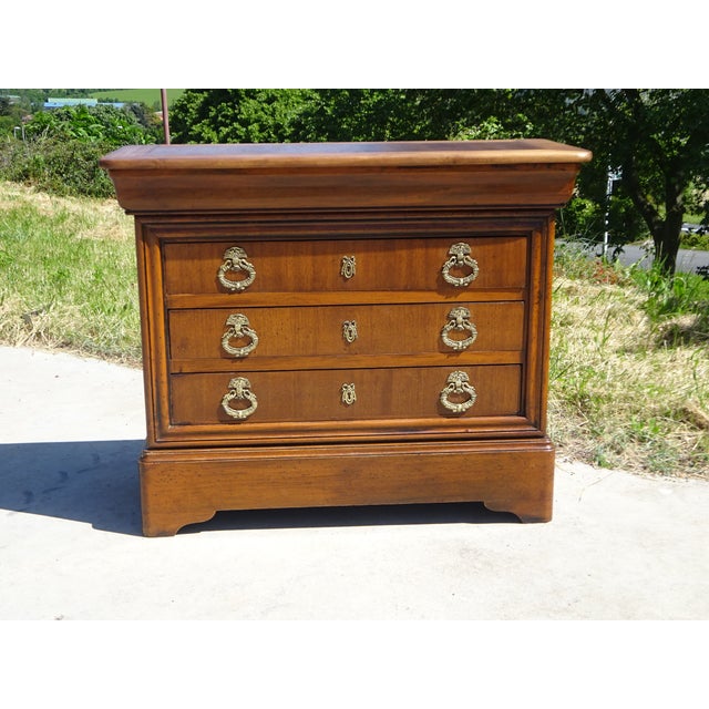 Beautiful chest of drawers in golden honey-colored wood, featuring four drawers, one of which is ogee-shaped. Gilt bronze...