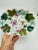 This is a decorative porcelain serving dish with a scalloped edge. It features a floral and leaf motif in vibrant green,...