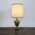 Ornate Neoclassical-style table lamp featuring an urn-form body in a mottled olive green finish with antiqued gilt...