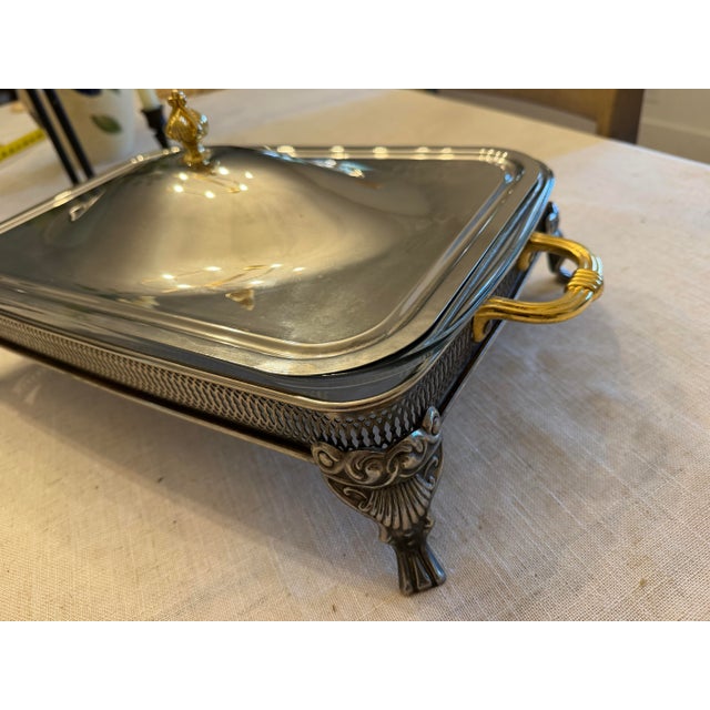 Vintage silverplate covered casserole server featuring an ornate footed frame, pierced gallery detail, and removable glass...