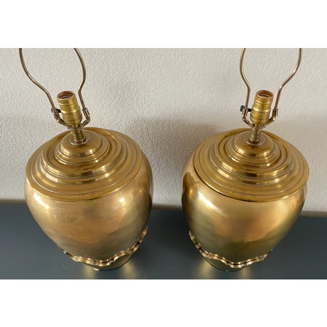 Magnificent pair of solid brass lamps from renowned Chapman Manufacturing Company. Round brass finial, concentric,...