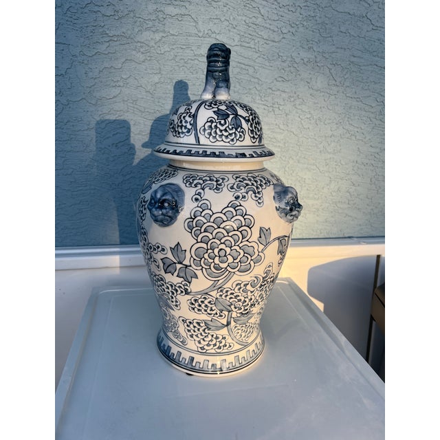 This vintage-style, hand-painted porcelain temple jar features a light blue/gray shade and white peony flower design and...