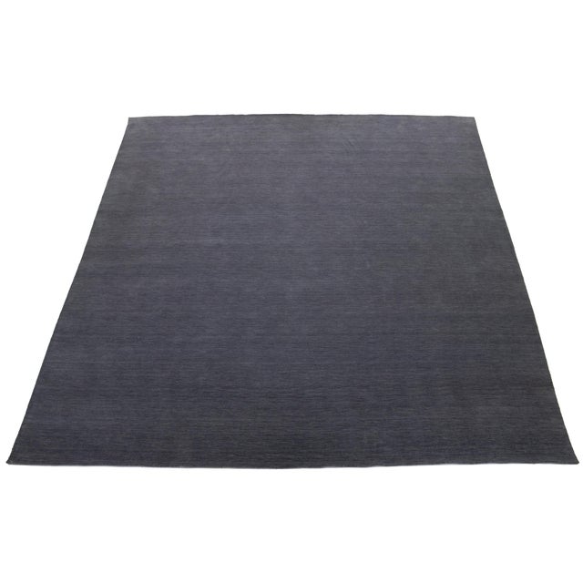 This handcrafted custom wool rug, designed in the Gabbeh style, features a solid gray design. It is part of our Desert...