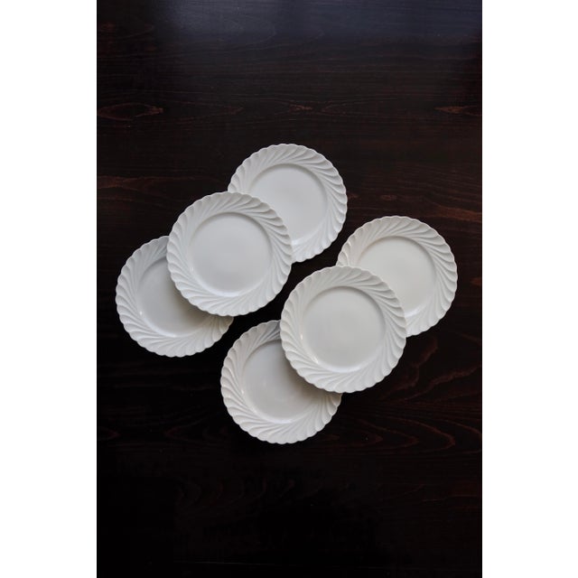 Elegant set of six fine white porcelain dinner plates, signed Haviland Limoges. The twisted rim features a refined relief,...