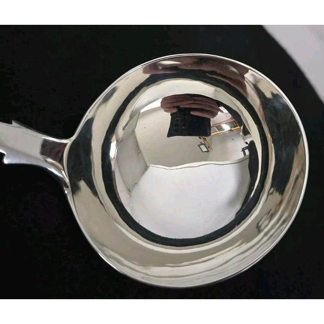 A fine Victorian sterling silver soup or punch ladle dating to 1854, crafted in the classic Fiddle pattern with...