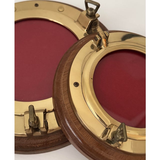 A rare matching pair of authentic brass hinged frames with original felt inserts, hardwood surrounds, and ship-grade...