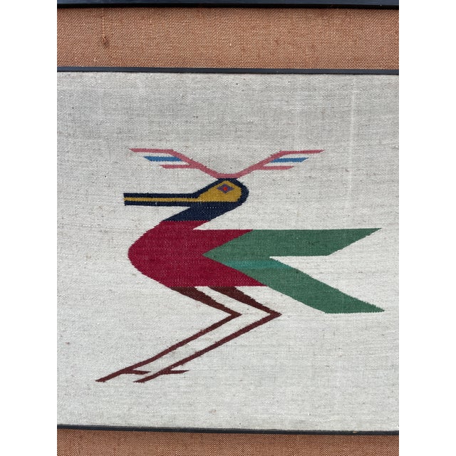 This beautiful hand-woven flat-weave wool textile features a stylized multicolored bird with geometric wings and crest. It...