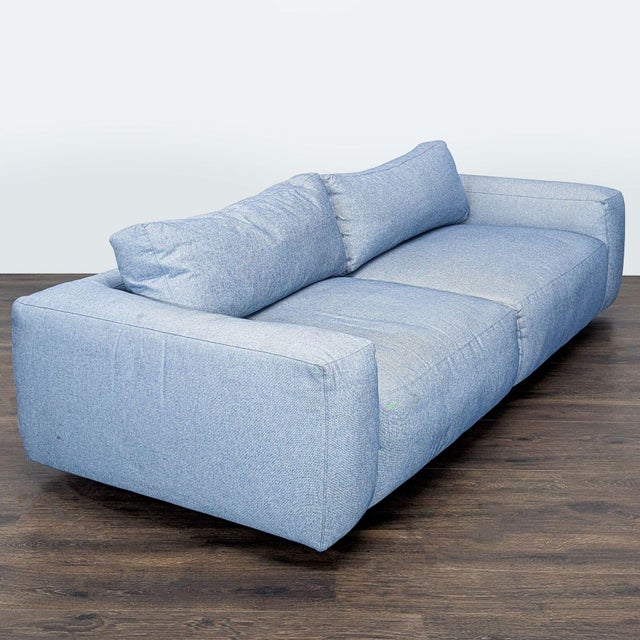 This Four Hands 3-seat sofa offers a modern and comfortable look with its light blue upholstery and wide, padded arms. The...