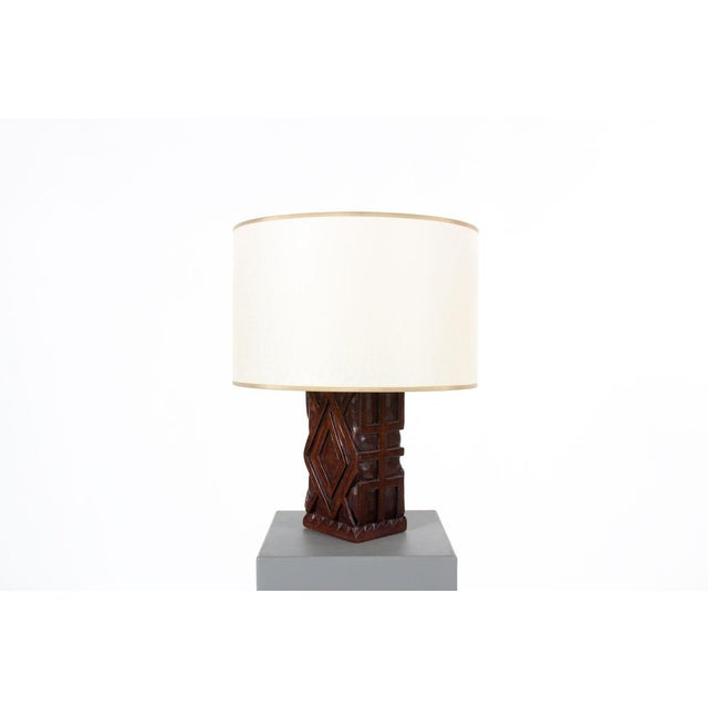 This vintage table lamp is distinguished by its sculptural silhouette and African-inspired design. The base is hand-carved...