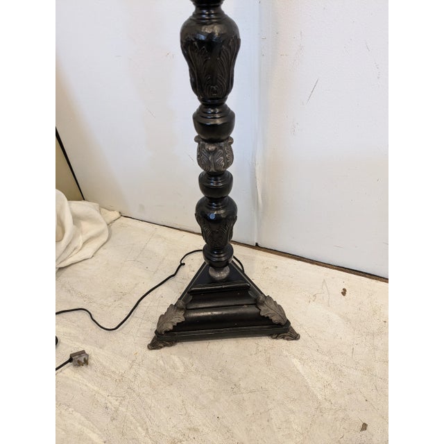 This ebonized carved wood floor lamp has pewter tone metal accents. You can use two Edison base bulbs up to 100 Watts each.