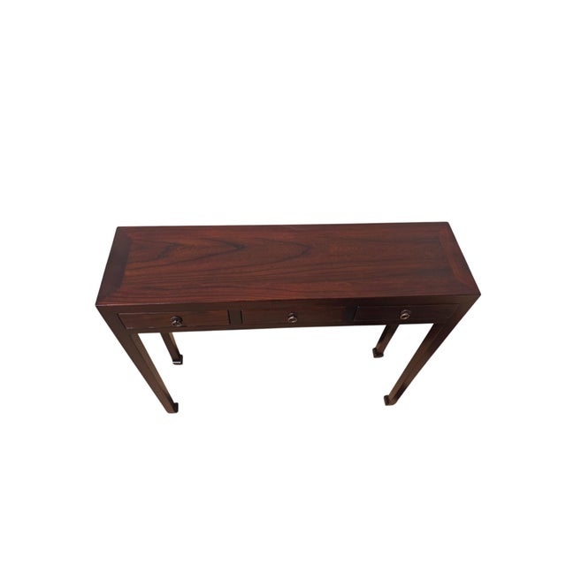 This vintage console table features three side-by-side storage drawers, each accented with traditional metal hardware and...