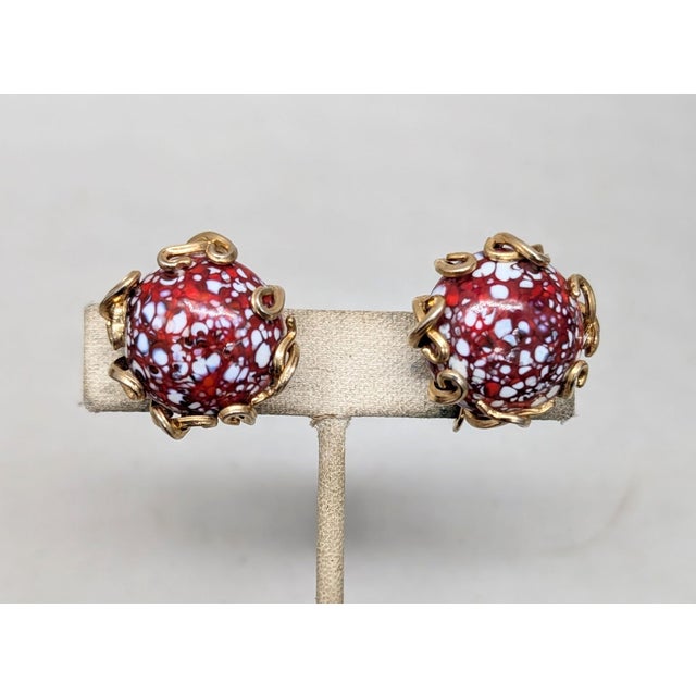 1960s goldtone round domed red art glass speckled with white and blue with goldtone looped edge clip earrings. Marked...