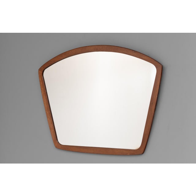 Shaped wall mirror with solid teak frame and original glass. Stamped. Denmark circa 1960.